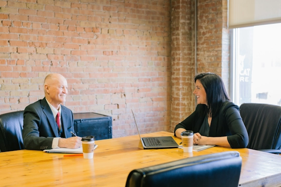 An expert from Beautiful Minds meets with school district legal counsel in a conference room